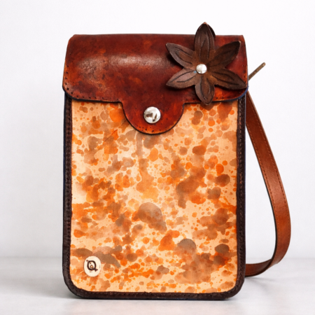 Bolso bandolera de cuero artesanal con flor en relieve y acabado marmolado en tonos tierra