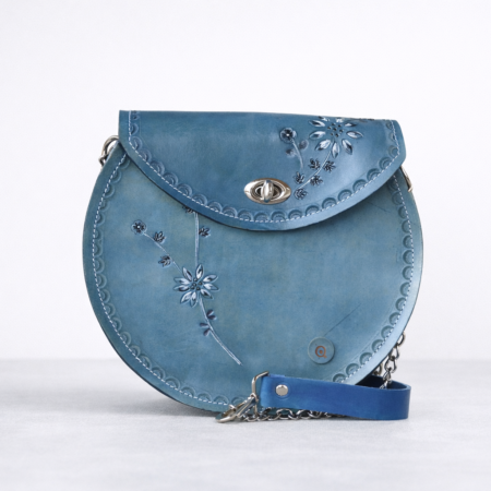 Bolso de cuero azul artesanal redondo con grabado floral en relieve y cadena