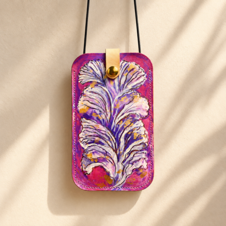 Porta móvil artesanal de cuero Pajarico con diseño de pluma violeta pintada a mano sobre fondo fucsia.